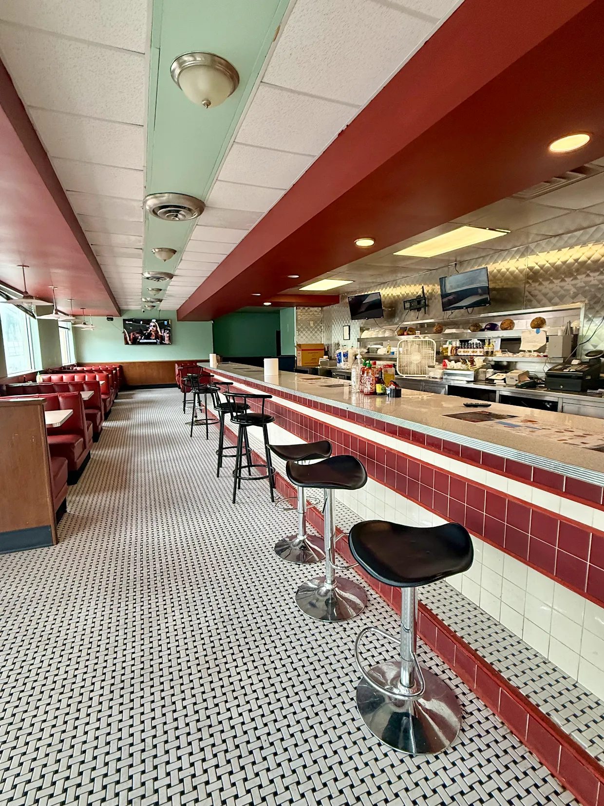 The classic diner counter and red booths inside Khmer Bowl